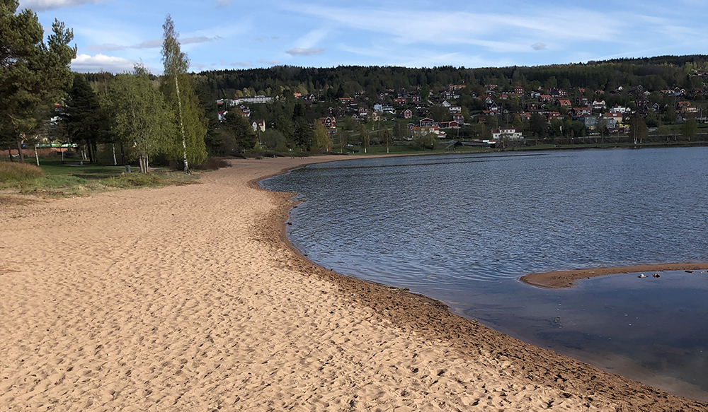 The beach at Siljan lake in Rättvik, Sweden - with an overvies of a part of Rättvik city.